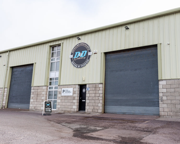 Front of the D&D Detailing shop, warehouse with a black door and metal shutter door